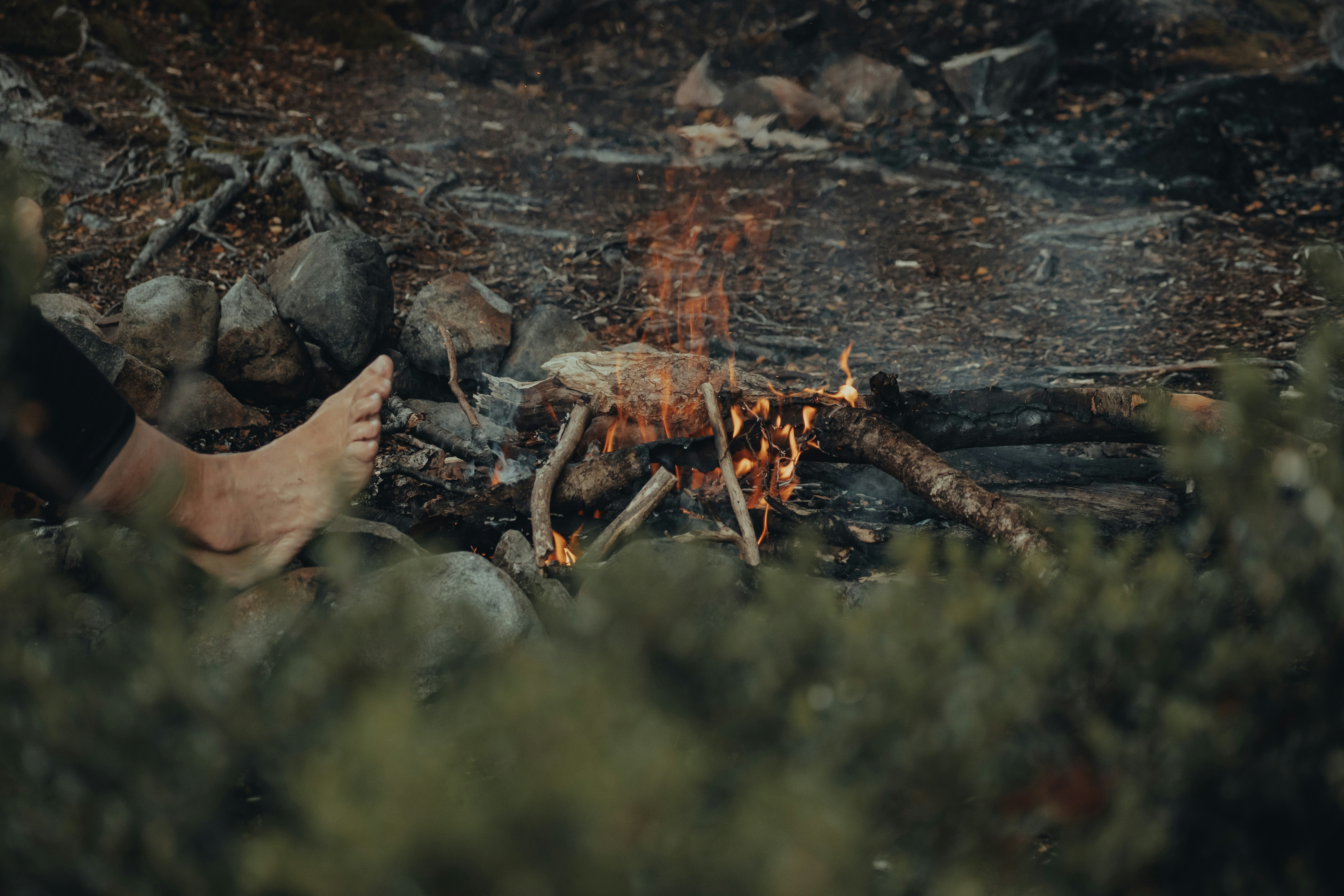 a person sitting in front of a campfire
